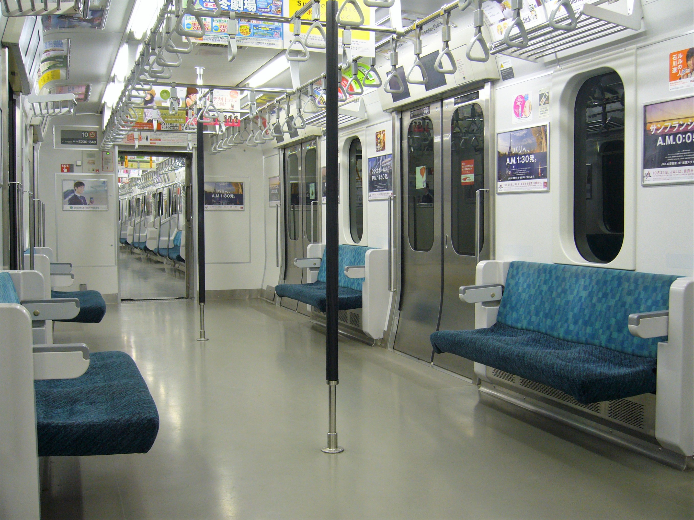 Inside a Japanese commuter train with hanging ads